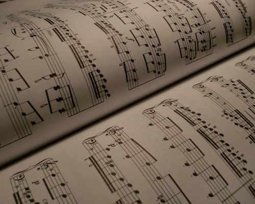 Detailed view of an open music book displaying musical notes and sheet music.